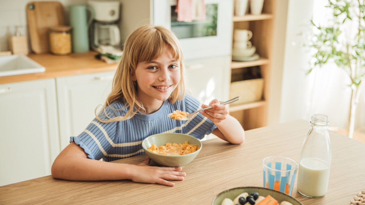 une enfant mange des céréales du petit-déjeuner
